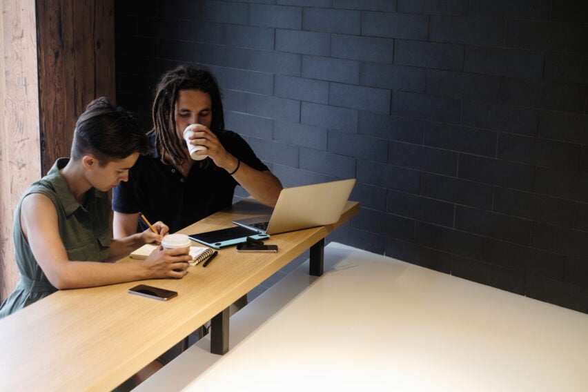 Cool looking couple work with laptop in modern interior