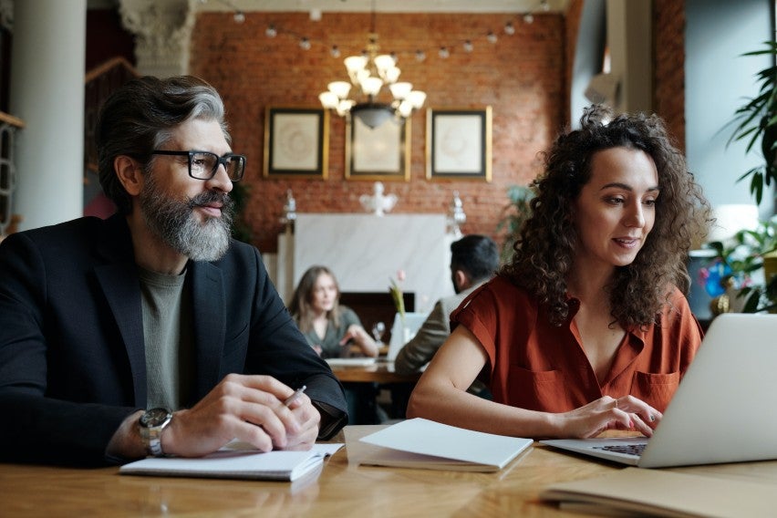 Man and woman looking at laptop in coworking space