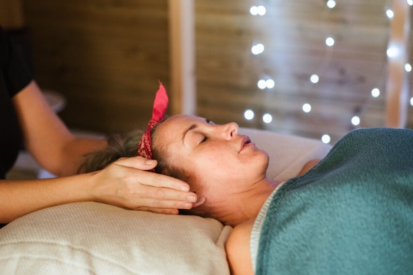 woman lying down at spa getting temple massage