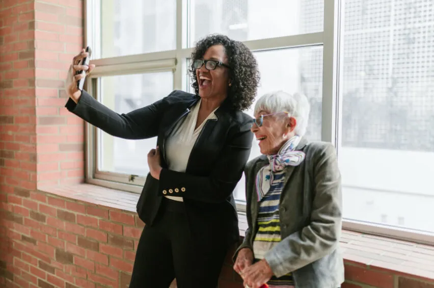 two professional women taking selfie in work setting