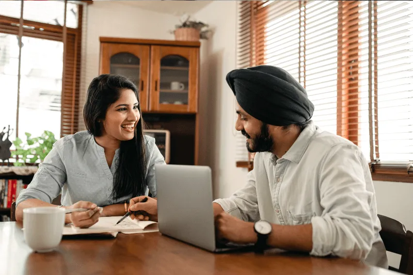 Man and woman smiling together while working at table