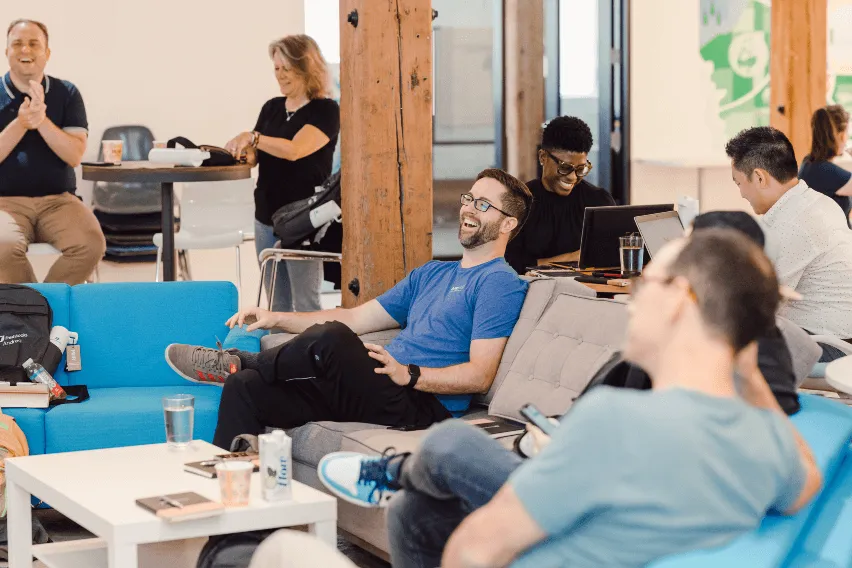 A group of accountants sit in a common area laughing