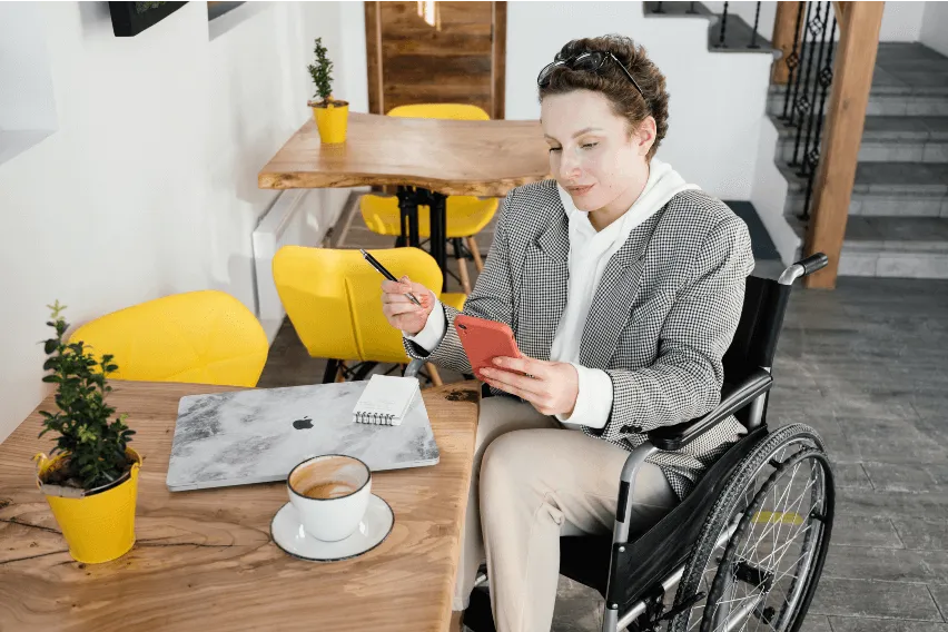 Woman sits at cafe table while looking at her phone